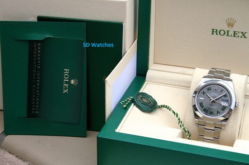 IMG_7132 | SD Watches Rolex watch displayed in a beige box with green outer packaging and a green warranty card nearby.