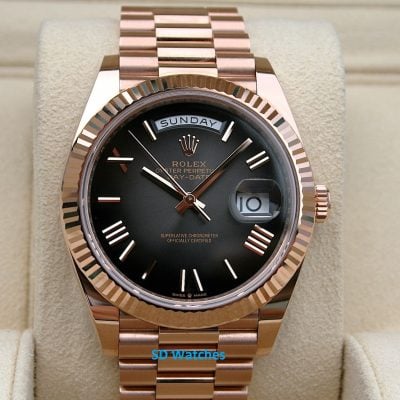 Rolex 228235 | SD Watches Rose-gold Rolex Day-Date wristwatch with black dial, day display at top, date window with magnifier on a beige cushion.