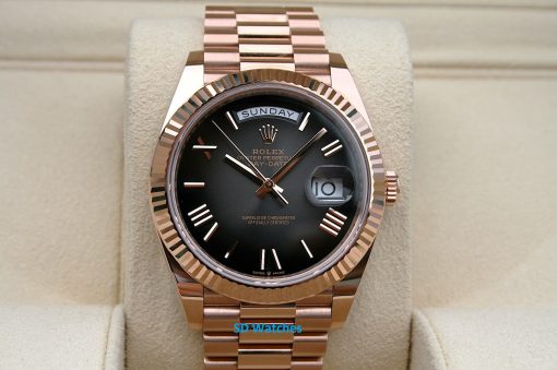Rolex 228235 | SD Watches Rose-gold Rolex Day-Date wristwatch with black dial, day display at top, date window with magnifier on a beige cushion.