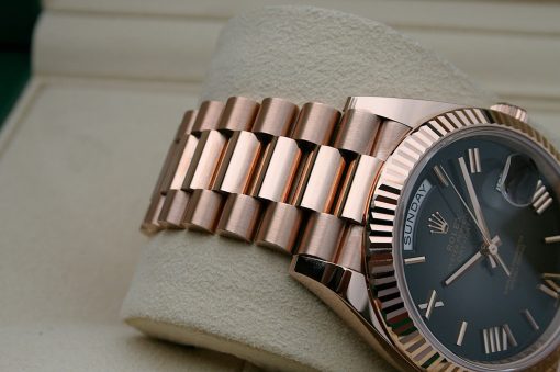 IMG_7145 | SD Watches Close-up of a rose-gold metal watch band and partial watch face on a beige cushion surface.
