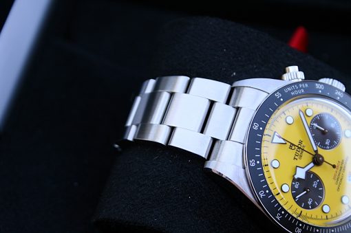 IMG_7195 | SD Watches Close-up of a stainless steel chronograph watch with a bright yellow dial and multiple subdials on a dark surface, bracelet extending to the left.