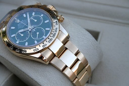 IMG_7209 | SD Watches Close-up of a gold-tone chronograph wristwatch with a blue dial and metal bracelet on a soft surface.