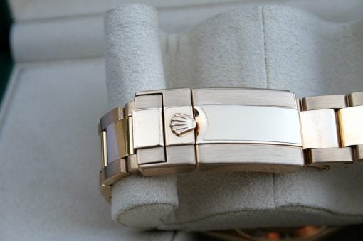 IMG_7211 | SD Watches Close-up of a silver metal watch bracelet with a clasp bearing the Rolex crown logo on a soft gray background.