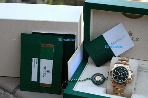 IMG_7219 | SD Watches Gold Rolex watch in a green presentation box with accompanying cards and green leather wallet nearby, showcasing luxury packaging.