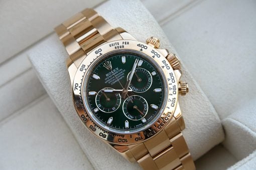 IMG_7220 | SD Watches Roseβgold Rolex chronograph watch with a green dial and multiple subdials resting on a beige cushioned surface.