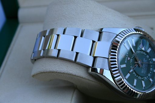 IMG_7231 | SD Watches Close-up of a stainless steel Rolex watch with a fluted bezel and metal bracelet resting on a beige surface