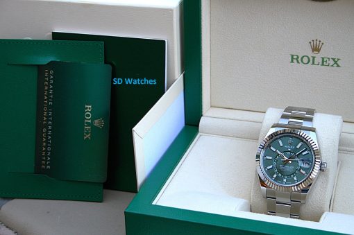 IMG_7240 | SD Watches Rolex watch with a green dial in an open beige-and-green presentation box, stainless steel band visible.