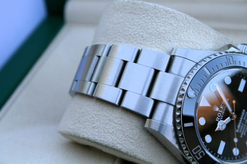 IMG_7250 | SD Watches Close-up of a stainless steel Rolex watch with a metal bracelet resting on a beige cushion.