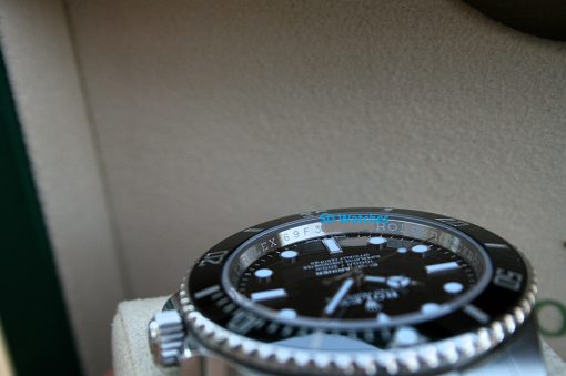 IMG_7253 | SD Watches Close-up of a Rolex watch bezel and dial on a beige background, with a blue SD Watches watermark over the face.