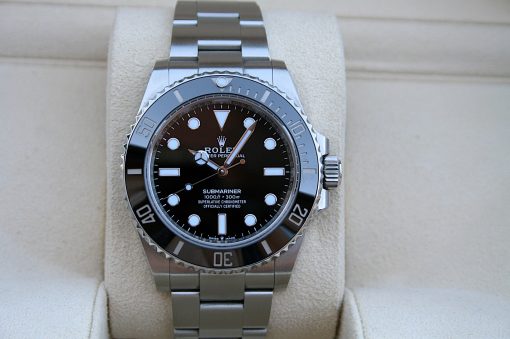 IMG_7260 | SD Watches Rolex Submariner wristwatch with black dial and stainless steel band on a beige display cushion on a jewelry stand