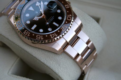 IMG_7266 | SD Watches Close-up of a silver Rolex watch on a light gray cushion, showing the dark dial and two-tone bezel with large numerals.