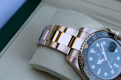 IMG_7267 | SD Watches Close-up of a two-tone Rolex diving watch with a blue bezel resting on a light cushion.