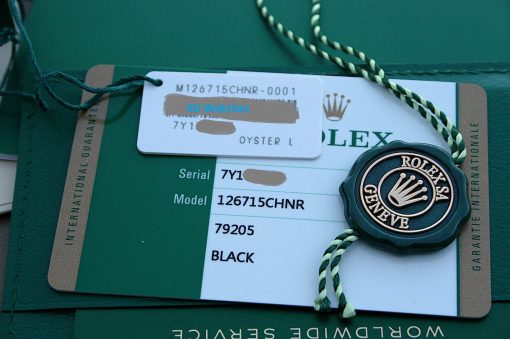 IMG_7274 | SD Watches Close-up of a Rolex watch tag attached to a green warranty card, with a white label and green-and-white cord visible.