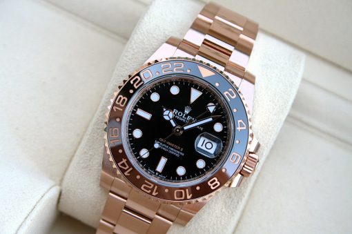 IMG_7281 | SD Watches Rose gold Rolex GMT-Master II wristwatch with a black dial, 24-hour bezel, and date window on a beige cushion.