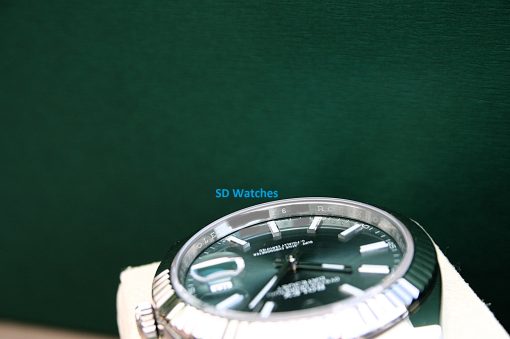 IMG_7291 | SD Watches Close-up of a stainless steel wristwatch on a green background with a blue 'SD Watches' watermark.