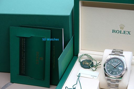 IMG_7294 | SD Watches Open Rolex box showing a stainless steel Datejust watch with white dial and date window on a cream interior, plus warranty card and tags nearby.