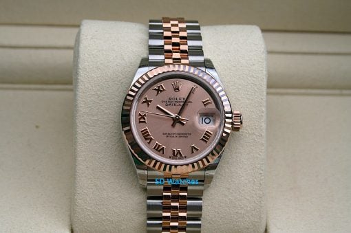 Rolex 279171 | SD Watches Two-tone Rolex Datejust wristwatch with pink dial, Roman numeral hour markers, and a date window on a beige display cushion.