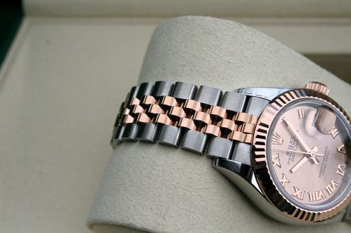 IMG_7304 | SD Watches Two-tone Rolex watch with silver and rose-gold bracelet resting on a light cushion, pink dial with Roman numerals and date window