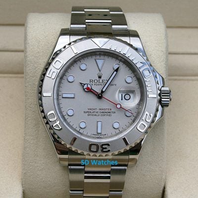 Rolex 116622 | SD Watches Close-up of a silver Rolex Yacht-Master watch on a beige display cushion, with a date window at 3 o'clock and a white dial.