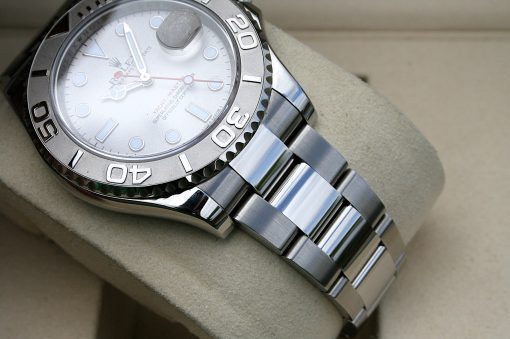 IMG_7322 | SD Watches Close-up of a stainless steel Rolex watch resting on a beige cushion, showing the silver dial and bold bezel numbers.