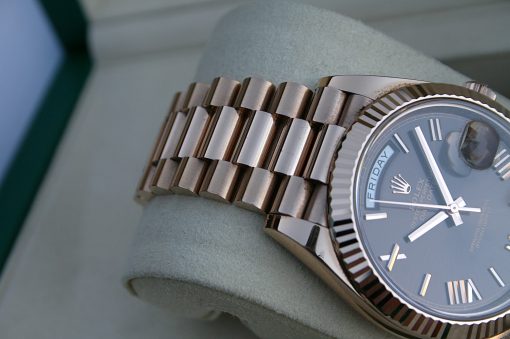 IMG_7358 | SD Watches Close-up of a Rolex wristwatch with a ridged bezel and metal bracelet resting on a soft cushion.