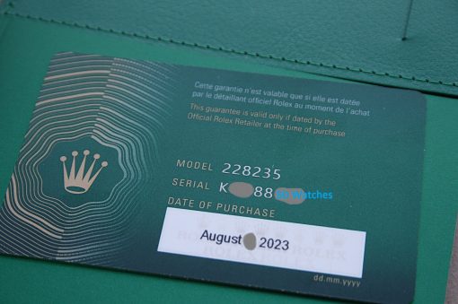 IMG_7363 | SD Watches Green Rolex warranty card with crown logo, date August 2023, tucked into a green wallet piece-by-piece visible edges.