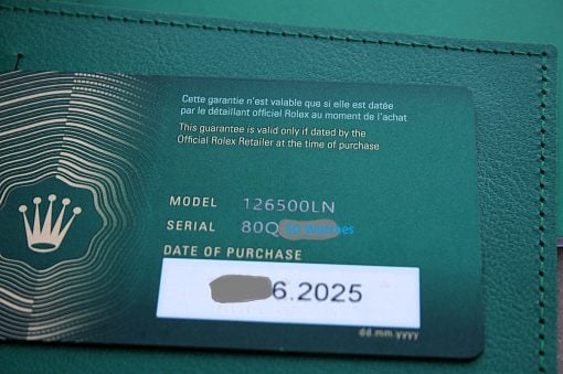 IMG_7382 | SD Watches Green Rolex warranty card inside a matching green wallet, showing model and serial details and a date of purchase stamp/label; text includes warranty language in French and English.