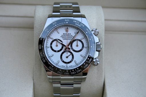 IMG_7385 | SD Watches Rolex Daytona wristwatch with white dial and black subdials on a silver bracelet, resting on a beige cushion.