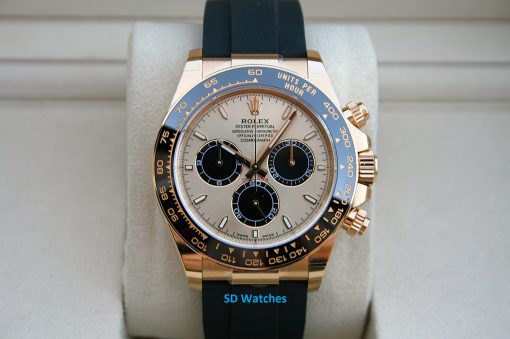 Rolex 126518 | SD Watches Close-up of a gold Rolex Daytona watch with a blue bezel on a light display cushion with a black strap.
