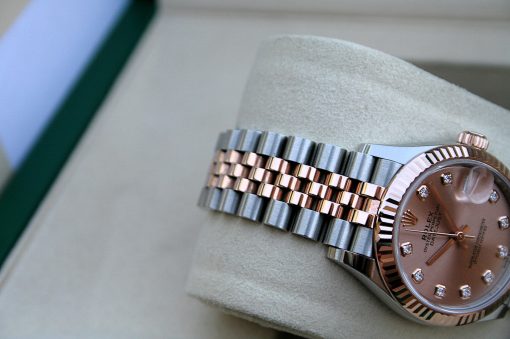 IMG_7413 | SD Watches Close-up of a two-tone Rolex Datejust watch with a rose-gold dial and diamond markers on a soft cushion