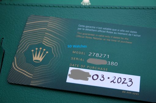 IMG_7422 | SD Watches Close-up of a green Rolex warranty card on green fabric, with crown logo, model and purchase fields, and a blue 'SD Watches' watermark (text partially blurred).