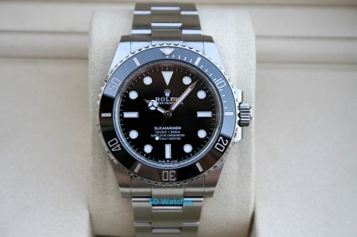 Rolex 124060 | SD Watches Rolex Submariner watch with black dial, silver bezel, and stainless steel bracelet on a beige cushion.