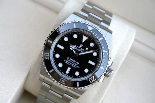 IMG_7444 | SD Watches Close-up of a stainless steel Rolex Submariner watch with a black dial and rotating bezel on a light background, highlighting its polished links and bold markers
