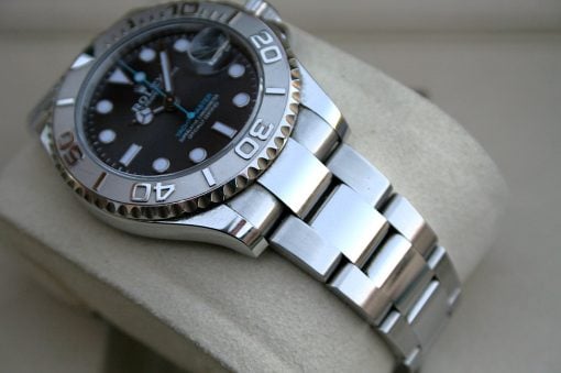 IMG_7448 | SD Watches Close-up of a stainless steel Rolex watch with a black dial and silver bezel on a beige cushion.